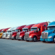 Ligne de camions d'occasion variés dans un grand parking ensoleillé